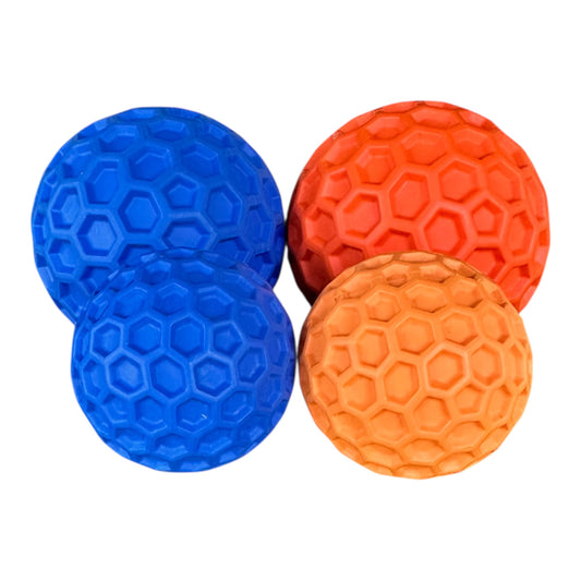 Four textured rubber dog balls. Two in blue and two in orange. 